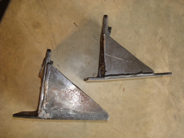 two welded metal brackets on a workbench