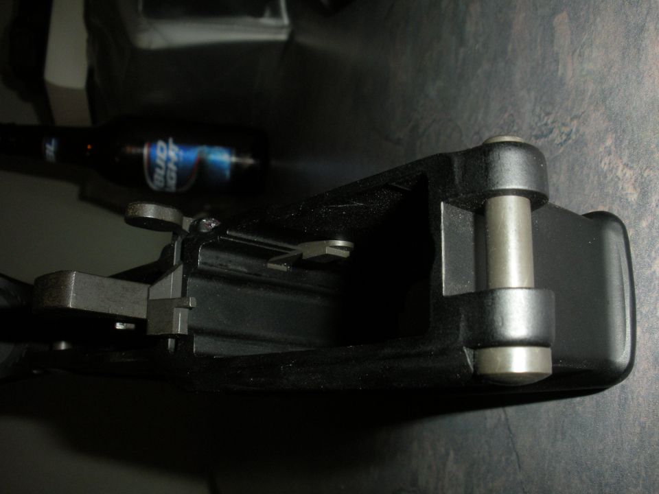 Black car door latch mechanism with a Bud Light bottle in the background