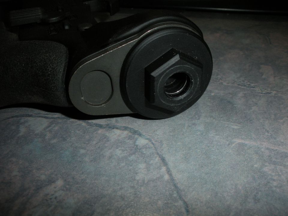 Close-up of a black metal part with a hexagonal nut recess