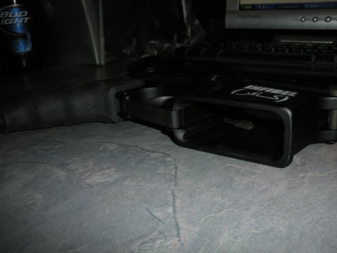 1996 Ford Bronco - A close-up view of a black gun receiver, marked with 'INFIDEL', is shown on a textured surface.
