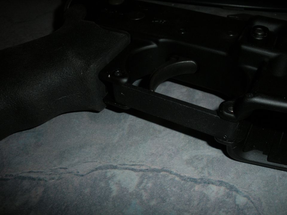 Close-up of a gun trigger assembly with a textured grip