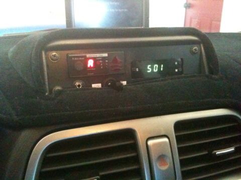 2005 Subaru Impreza - Interior view of a car dashboard, focusing on an aftermarket electronic device and digital clock display.