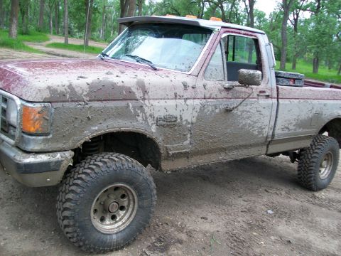 1988 Ford F-150 - This 1988 Ford F-150 pickup truck is heavily covered in mud, suggesting off-road use.