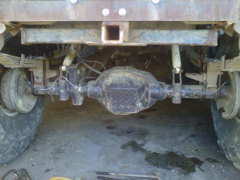 1992 Ford F-350 - The rear suspension and axle of a heavy-duty truck are visible, with a trailer hitch mounted above.