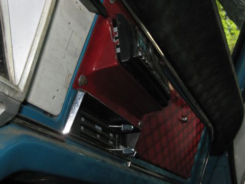 1972 Ford F-250 - The dashboard of a vintage truck shows a red accent panel around the radio and climate controls.