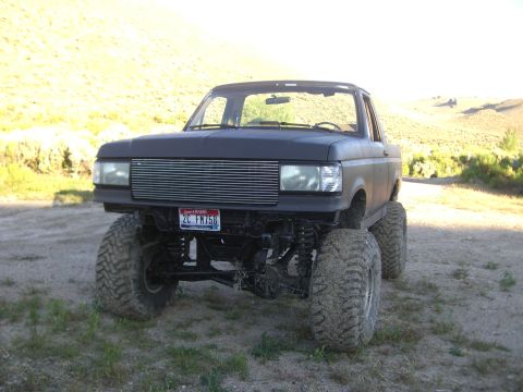 1987 Ford Bronco - This lifted 1987 Ford Bronco features a prominent chrome grille and aggressive off-road tires.