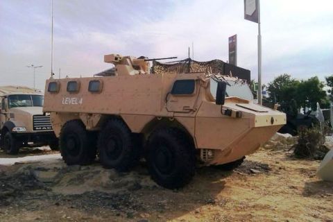 1991 Ford Crown Victoria - Armored personnel carrier with a mounted weapon system is seen next to a truck.