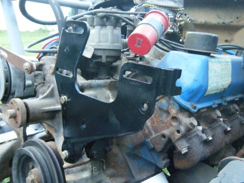 1978 Ford Bronco - A black metal bracket is attached to the engine block, obscuring part of the distributor and valve cover.