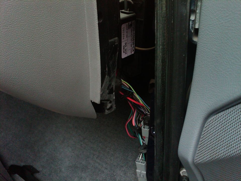 Close-up of exposed wiring harness and connectors inside a vehicle's dashboard area