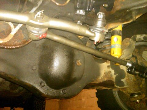 1995 Ford Bronco - Underside view of a vehicle's steering and suspension system, showing the differential and a yellow shock absorber.