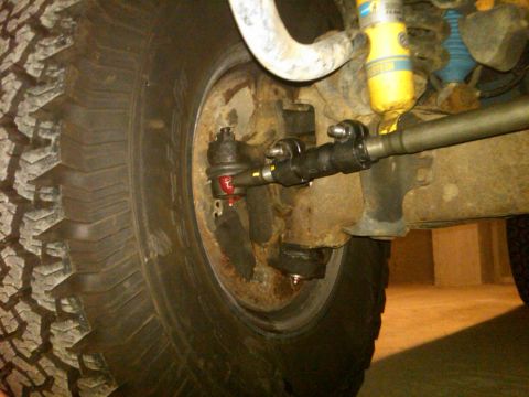 1995 Ford Bronco - Detail of a vehicle's suspension system and tire, with "SUPERMOTORS" visible in the lower right corner.