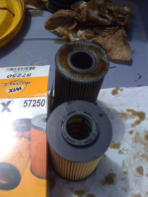 2010 Hyundai Genesis - Oil filters and a WIX 57250 box are shown with oil stains on a cloth.