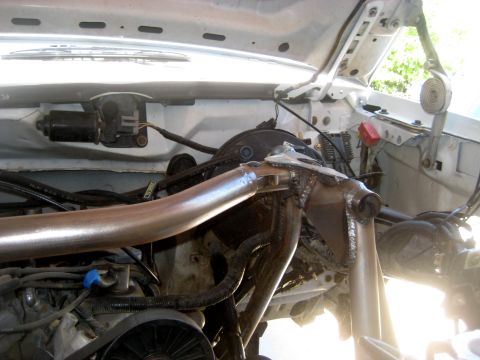 1996 Ford Bronco - Custom suspension components are installed in the engine bay of a white vehicle.