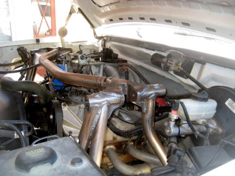 1996 Ford Bronco - Custom exhaust headers are visible in the engine bay, with the radiator coolant reservoir also in view.