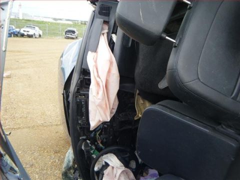 2005 Dodge 3500 - The interior of a vehicle shows significant damage, including deployed airbags and exposed wiring, with other vehicles in the background.