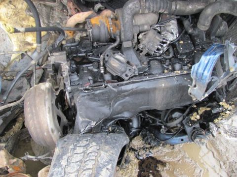 2005 Dodge 3500 - The engine and front wheel assembly of a severely damaged vehicle are shown in this close-up view.