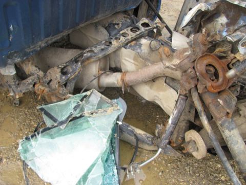 2005 Dodge 3500 - Undercarriage of a wrecked vehicle, showing extensive damage to suspension and exhaust systems.