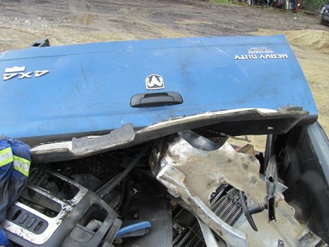 2005 Dodge 3500 - The tailgate of a blue pickup truck shows damage and the 'Heavy Duty' designation.