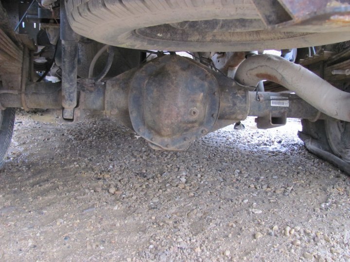 Rear axle and suspension of a truck, showing leaf springs, shock absorber, and exhaust pipe