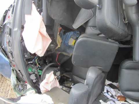 2005 Dodge 3500 - The interior of a severely damaged vehicle shows deployed airbags and extensive damage to the dashboard and seats.