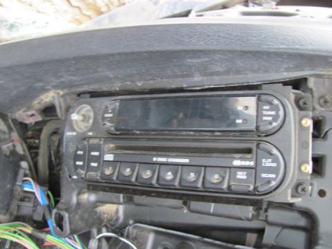 2005 Dodge 3500 - Close-up of a car's dashboard showing a multi-disc CD changer and radio controls.