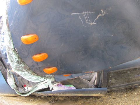 2005 Dodge 3500 - Side view of a damaged 2005 Dodge 3500 showing marker lights and shattered glass.