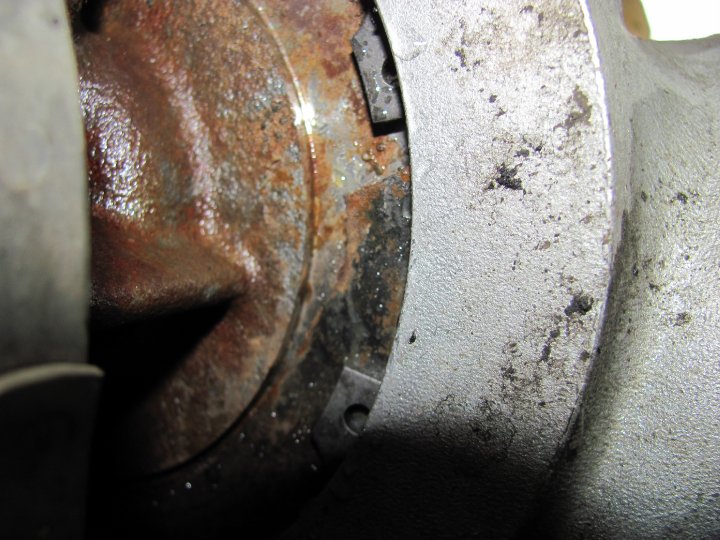 Close-up of a heavily rusted metal component with some grease and dirt