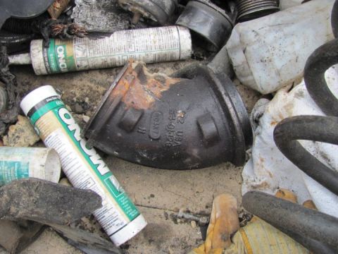 2005 Dodge 3500 - Scrap metal and assorted automotive parts are piled together, with no clear vehicle visible.