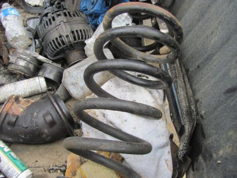 2005 Dodge 3500 - A collection of automotive parts, including a coil spring and an alternator, are piled together.