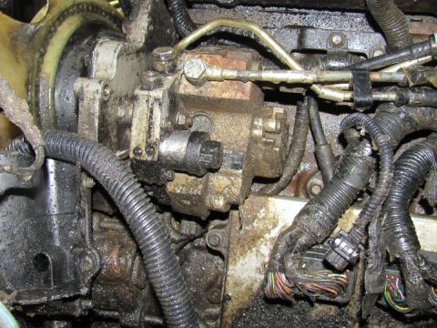 2005 Dodge 3500 - This image shows a close-up of a heavily soiled diesel engine fuel injection pump and associated wiring.