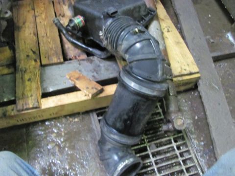 2005 Dodge 3500 - A black air intake hose and filter box assembly is shown resting on a wooden pallet.