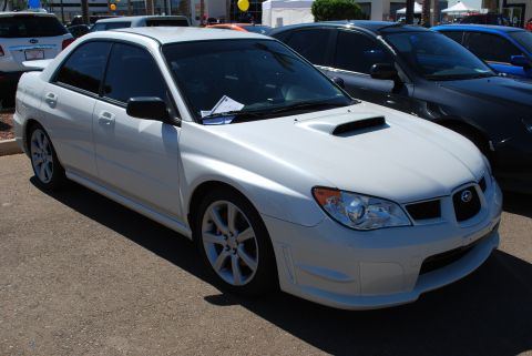 2005 Subaru Impreza - A white Subaru Impreza sedan is parked in a lot with other vehicles.