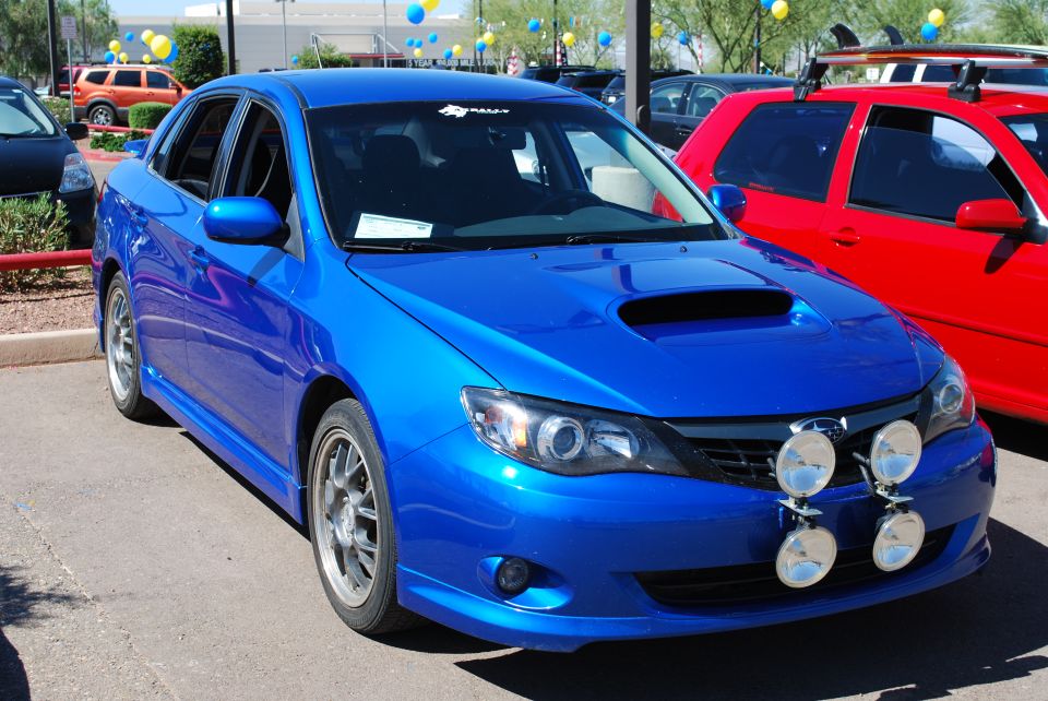 Blue 2008 Subaru Impreza WRX STI sedan with rally lights and hood scoop
