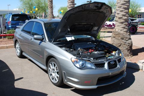 2005 Subaru Impreza - A gray 2005 Subaru Impreza sedan is displayed with its hood open, revealing the engine compartment.