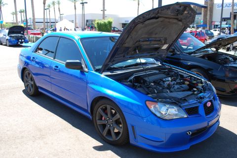 2005 Subaru Impreza - A blue Subaru Impreza WRX STI is displayed with its hood open at an outdoor car show.