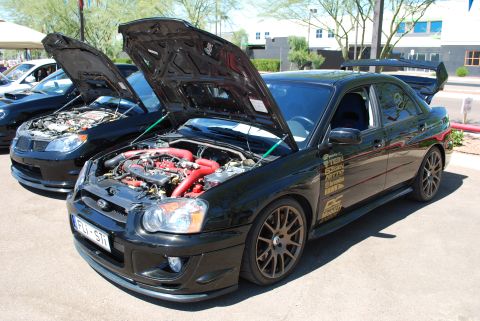 2005 Subaru Impreza - A black 2005 Subaru Impreza WRX STI is displayed with its hood open, revealing its engine bay and various aftermarket modifications.