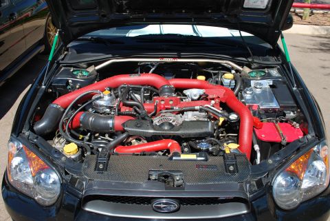 2005 Subaru Impreza - Engine bay of a 2005 Subaru Impreza, modified with red intake piping.