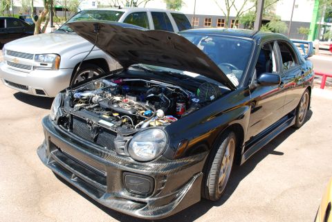 2005 Subaru Impreza - A modified Subaru Impreza WRX STI is displayed with its hood open, revealing the engine bay.