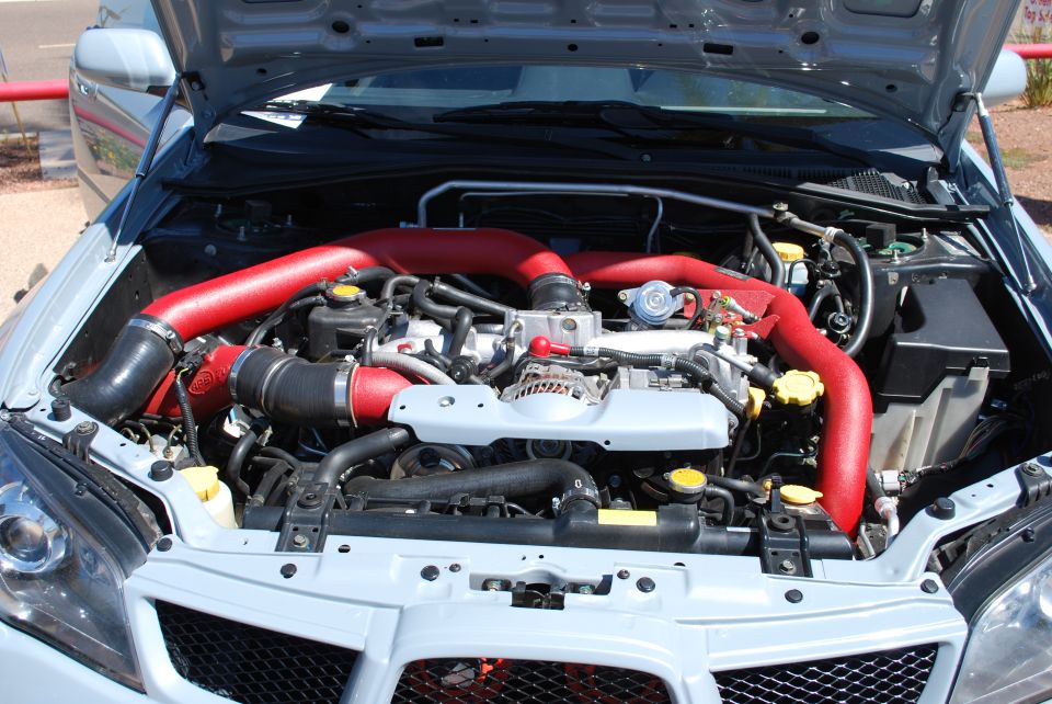 2005 Subaru Impreza engine bay with red intake piping