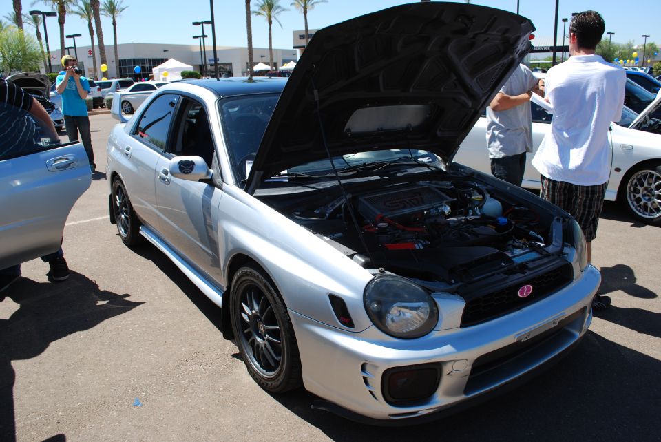 Silver Subaru Impreza WRX STI with hood open, showing engine. Black roof, black wheels