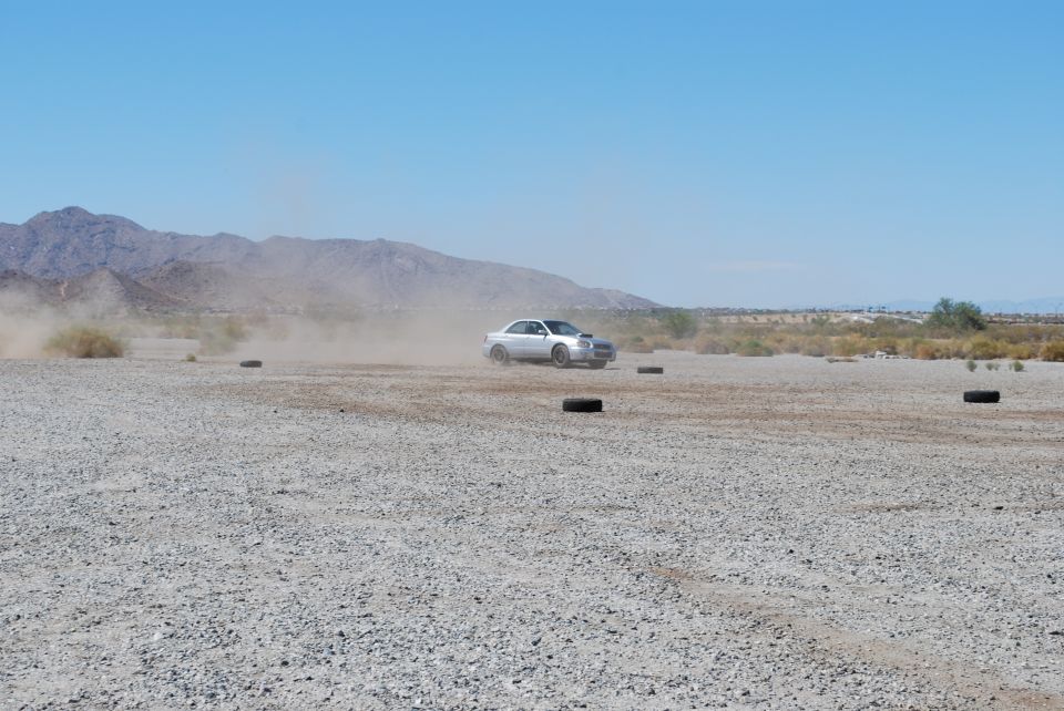 Silver 2005 Subaru Impreza WRX STI kicking up dust on a track
