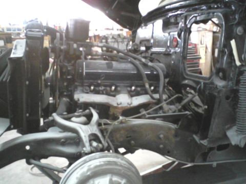 1960 Ford Falcon - Close-up view of a car's engine bay, revealing the engine and surrounding mechanical parts during a restoration.