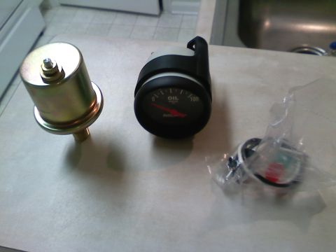 1990 Ford Bronco - Oil pressure gauge and sender unit, likely for a vehicle modification or repair.