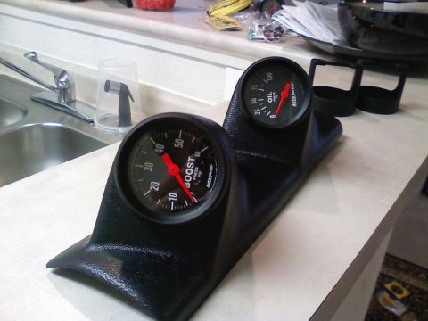 1990 Ford Bronco - A gauge pod with boost and oil pressure gauges is shown on a countertop.