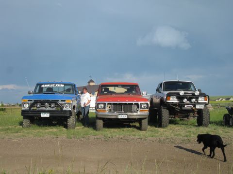 1978 Ford Bronco - Three Ford pickup trucks are parked in a grassy field under a cloudy sky.
