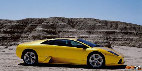 1998 Ford Crown Victoria - A bright yellow sports car is captured in a three-quarter front view against a backdrop of arid hills.