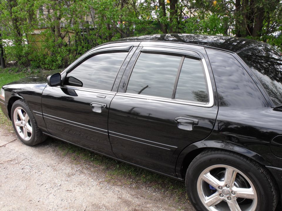 Black sedan, side view, showing tinted windows and chrome trim