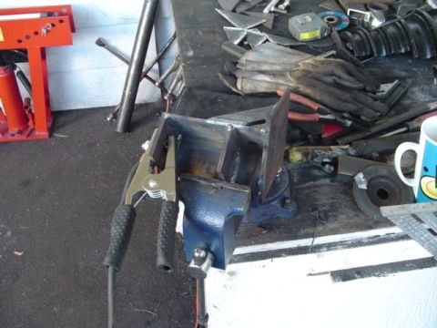 1993 Ford Bronco - Metal fabrication in progress, with a vise, clamps, and various tools on a workbench.