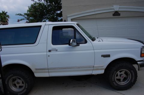 1994 Ford Bronco - Side profile of a white 1994 Ford Bronco with "BRONCO" badge visible.