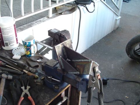 1993 Ford Bronco - A custom metal bracket is secured in a vise, indicating a fabrication or repair project in progress.